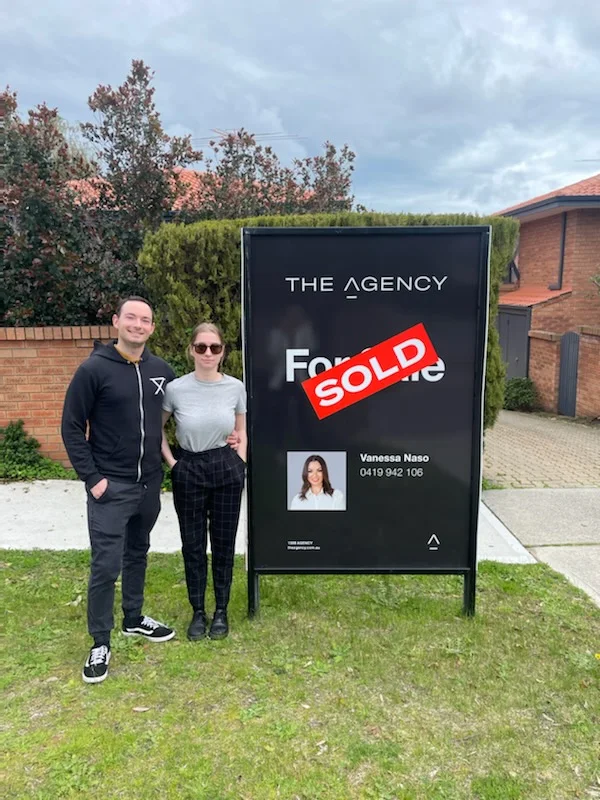 Aaron and Cheyenne beside another sold property sign